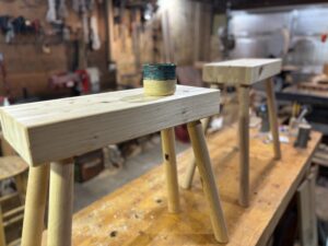 Two staked sawhorses in a workshop with a tea cup on top